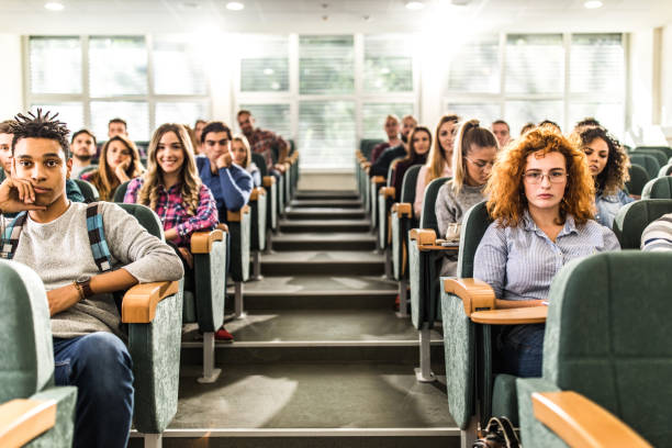 Large group of college students in a lecture hall. Large group of college students attending a class in amphitheater. audience in lecture hall stock pictures, royalty-free photos & images