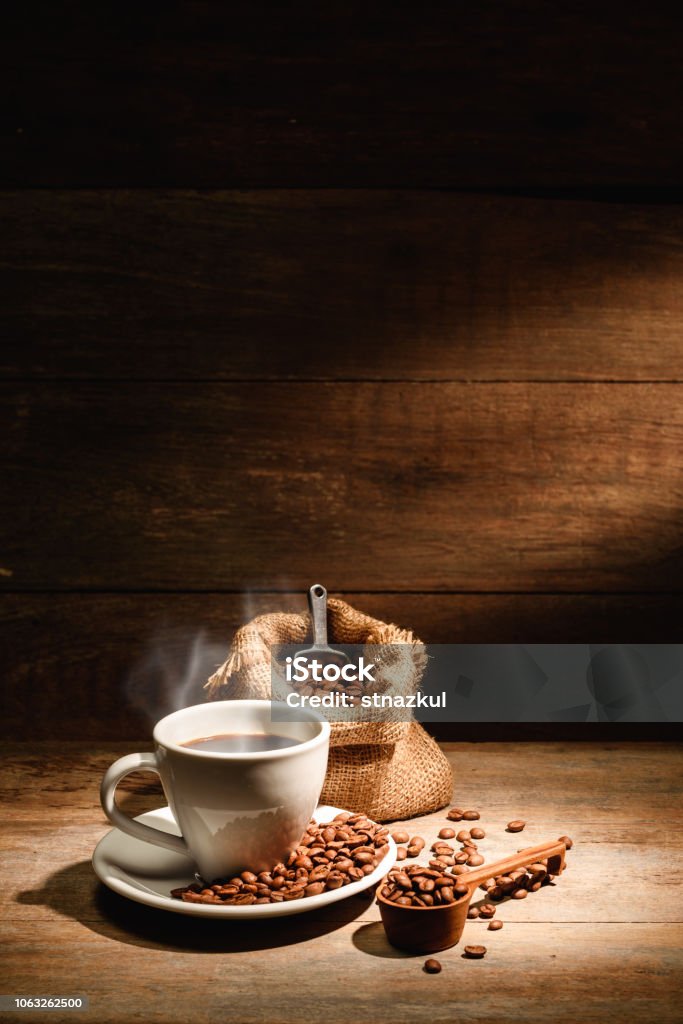 A cup of black coffee or americano with roasted coffee bean in bag, good coffee for health is black coffee without sugar and milk Backgrounds Stock Photo