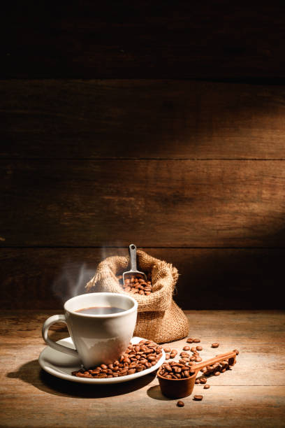 A cup of black coffee or americano with roasted coffee bean in bag, good coffee for health is black coffee without sugar and milk stock photo