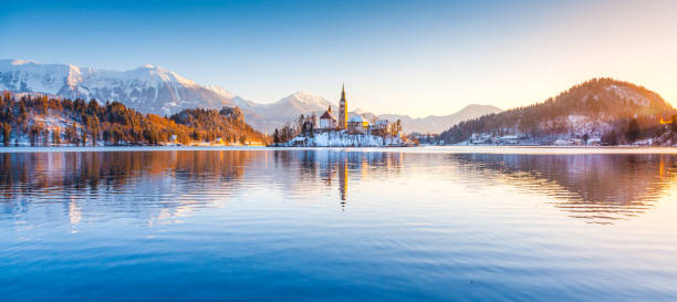 lac de bled avec l’île de bled et son château au lever du soleil en hiver, slovénie - castle slovenia winter snow photos et images de collection
