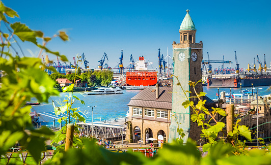 Amsterdam, Netherlands: Amsterdam Centraal train station in the distance with a canal and boats in the foreground. Copy space available in the white sky.