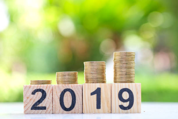 istock Growth of coins stack and wood blocks number 2019. 1063268560