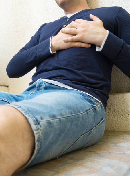 istock Man with a heart attack sitting on the ground. 1063268576