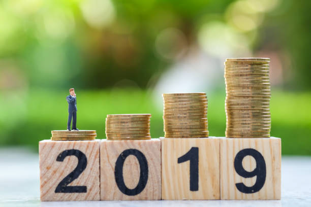 istock businessman miniature and stack of coins. 1063268644