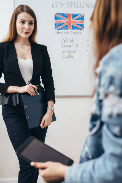 istock Two female students talking in classroom. College, English language school. 1063271942