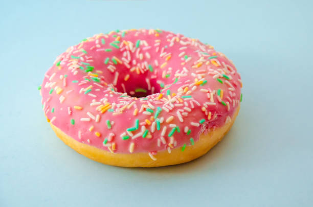 istock Delicious pink donut on a blue background floured 1063277306