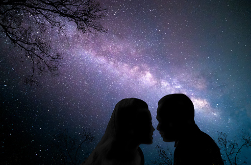 Couple of lovers kissing under the milky way, Galaxy background. Valentine's Day Concept