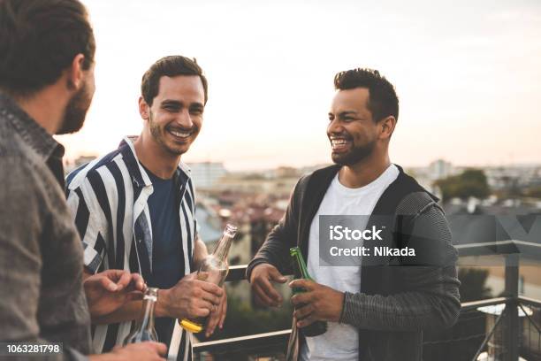 Cheerful Friends Enjoying At Rooftop Party Stock Photo - Download Image Now - Friendship, Men, Drinking