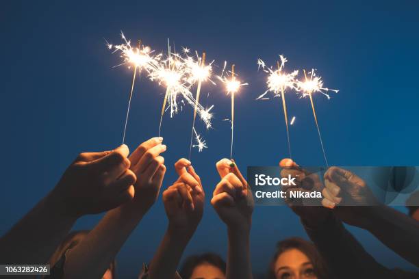 Friends Celebrating New Years Eve With Firework Stock Photo - Download Image Now - Sparkler - Firework, New Year's Eve, Friendship