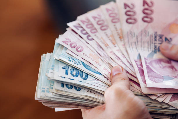 Turkish Lira Young man holding some one hundred and two hundred cash banknotes, Close up turkish lira photos stock pictures, royalty-free photos & images