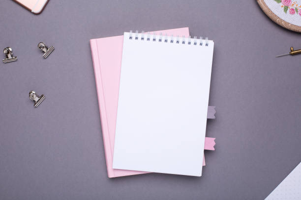istock White notepad with pink book on grey background in vintage style 1063290156