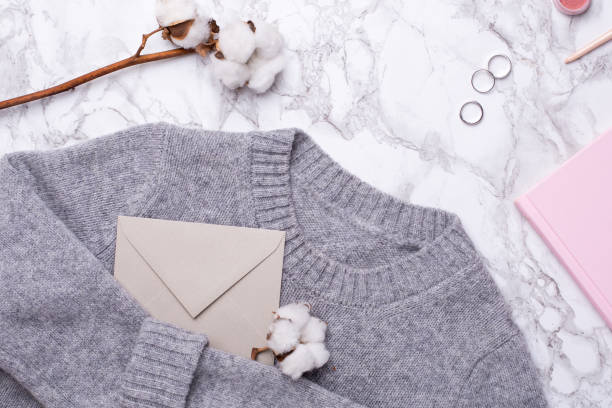 istock Cozy sweater with envelope , pink notebook and rings on marble background 1063290368