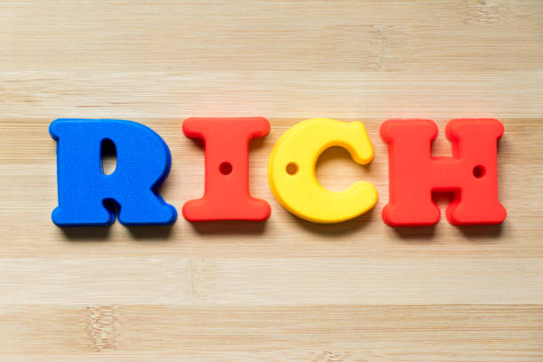 istock Color plastic alphabet in word rich on wood background 1063291518