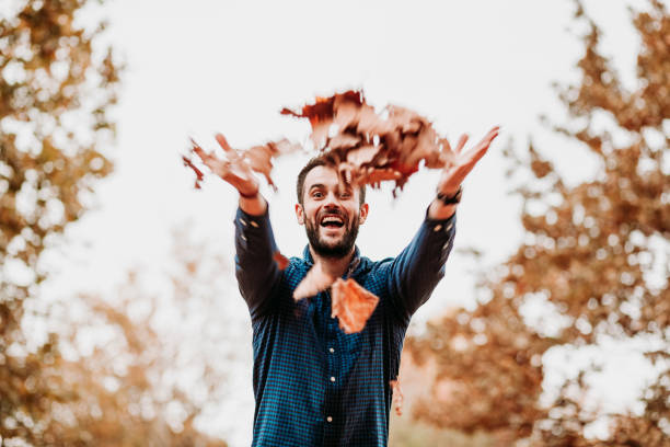 istock Young man throwing autumn leaves in the air 1063292194