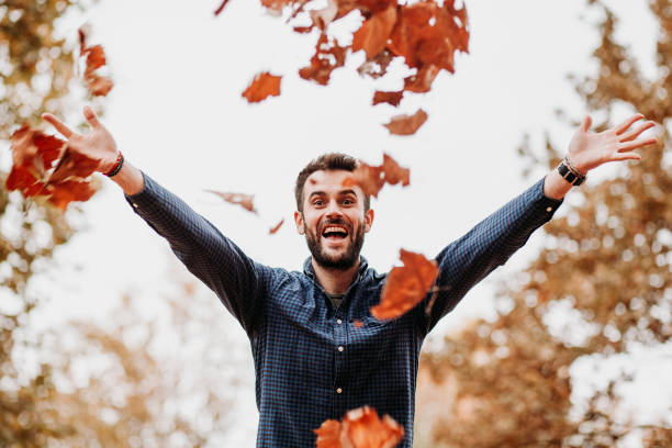 istock Young man throwing autumn leaves in the air 1063292196