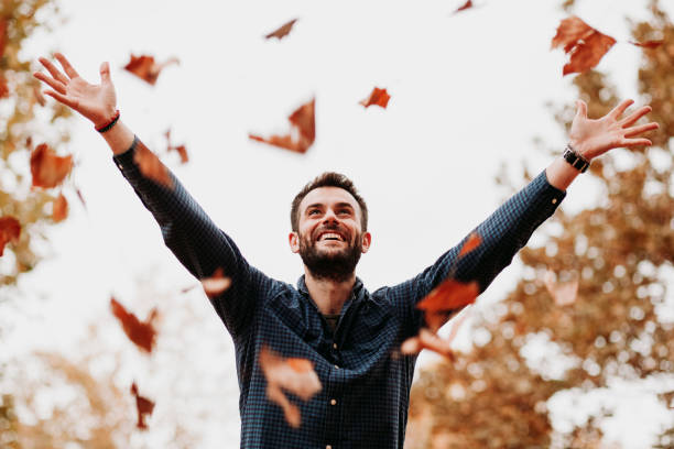 istock Young man throwing autumn leaves in the air 1063292198