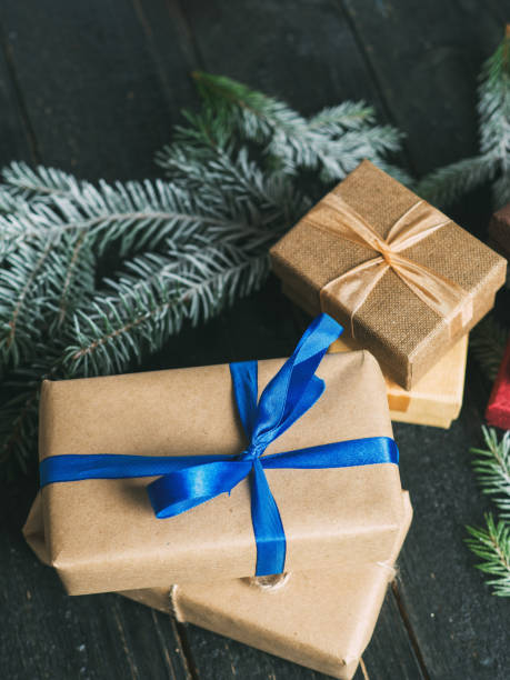 istock Lots of Christmas gift boxes on a dark wooden table with Christmas tree branches 1063293720