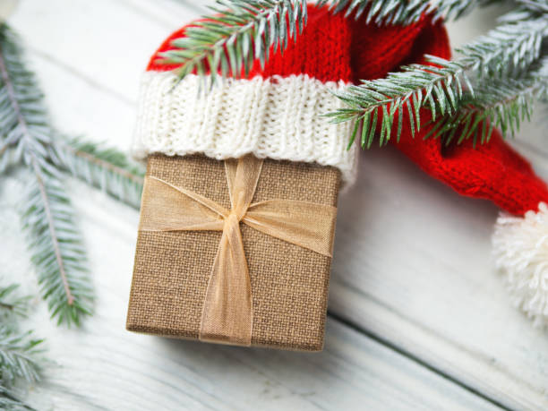istock Gift box with Christmas tree branches in Santa's red hat 1063293746