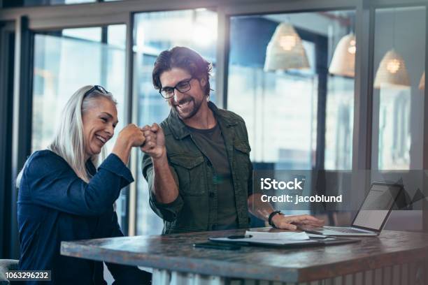 Colleghi Di Lavoro Che Fanno Un Pugno In Ufficio - Fotografie stock e altre immagini di Successo - Successo, Affari, Lavorare