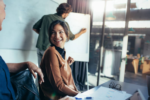 istock Woman smiling during business presentation in office 1063297040