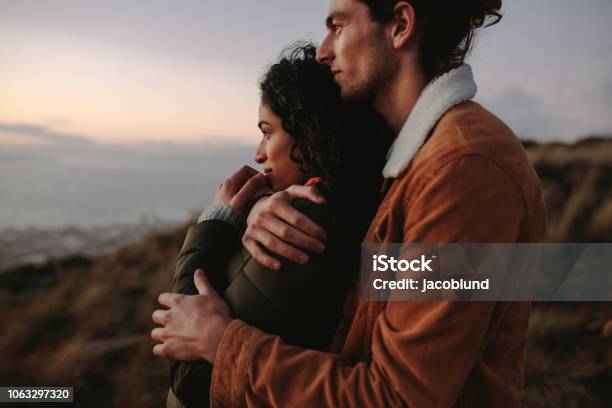 Romantic Young Couple Standing In Mountain Stock Photo - Download Image Now - Love - Emotion, Embracing, Young Couple