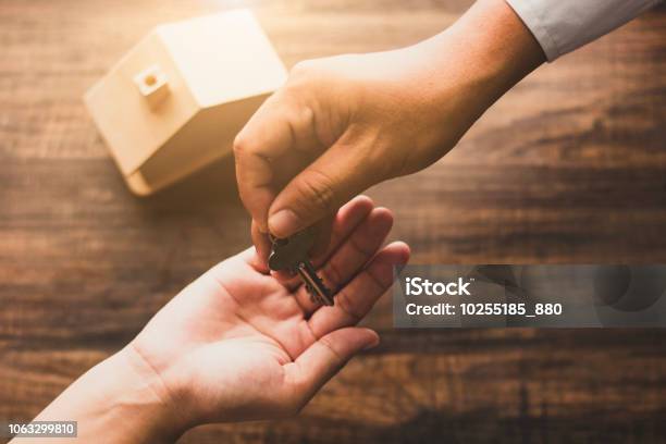 Real Estate Concept Home Agency Banker Give House Key To Owner Or Buyer On Wood Table In Vintage Tone Stock Photo - Download Image Now