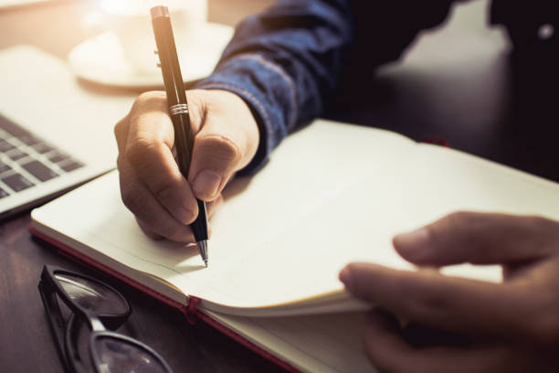 istock close up hand of people wearing jean writing diary and note information on working table at home 1063299854