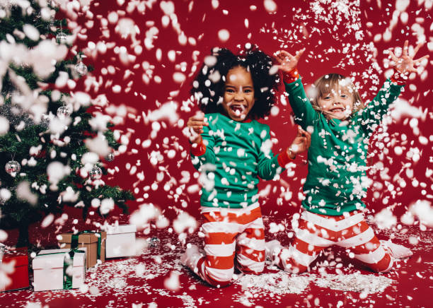 istock Kids enjoying the falling artificial snow during christmas 1063301552