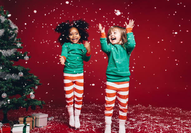 bambine che giocano con fiocchi di neve artificiali - christmas child foto e immagini stock