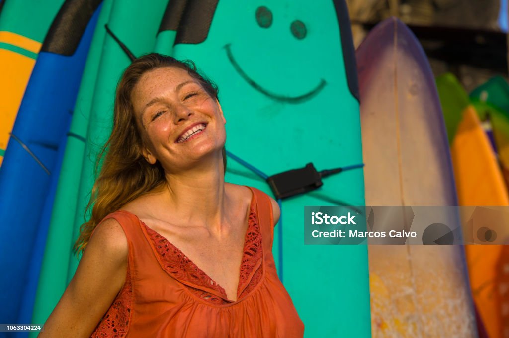 head and shoulders portrait of young beautiful and happy blond woman smiling relaxed and cheerful posing with colorful surf boards in the background in beauty fashion and summer holidays concept 30-39 Years Stock Photo