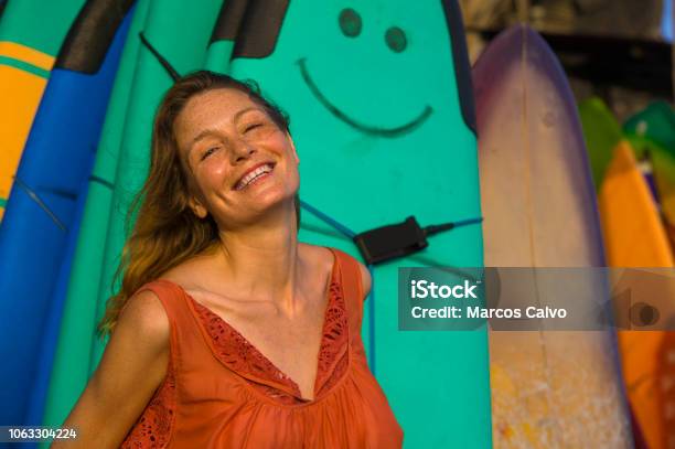 Head And Shoulders Portrait Of Young Beautiful And Happy Blond Woman Smiling Relaxed And Cheerful Posing With Colorful Surf Boards In The Background In Beauty Fashion And Summer Holidays Concept Stock Photo - Download Image Now