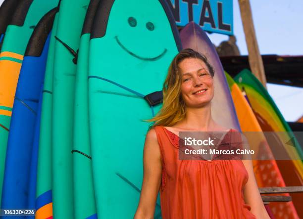 Head And Shoulders Portrait Of Young Beautiful And Happy Blond Woman Smiling Relaxed And Cheerful Posing With Colorful Surf Boards In The Background In Beauty Fashion And Summer Holidays Concept Stock Photo - Download Image Now