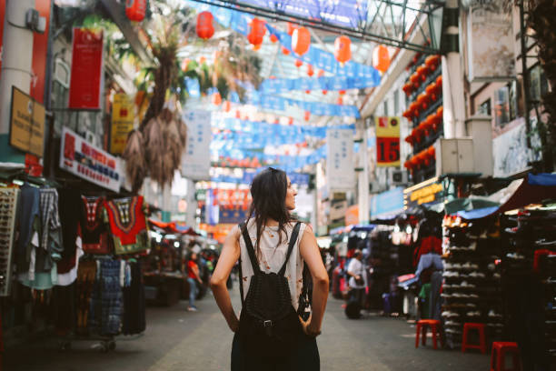 Young traveler woman in Kuala Lumpur Chinatown district Young traveler woman walking through the stalls in Chinatown district of Kuala Lumpur, Malaysia. kuala lumpur stock pictures, royalty-free photos & images