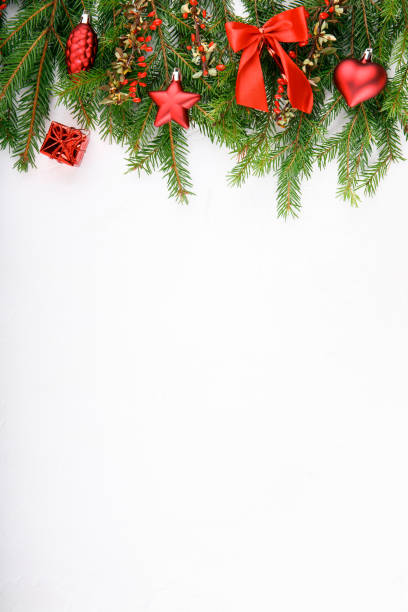 istock Spruce branches decorated with red ornaments and red barberry berries on a white background. Festive xmas fir tree. Top view. Copy space. Christmas or New Year background. 1063308228