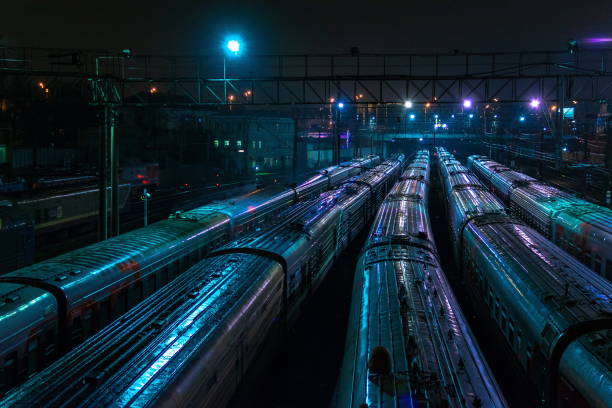 Many trains on the railway station at night, blue and violet lights on the background, transportation and travelling
