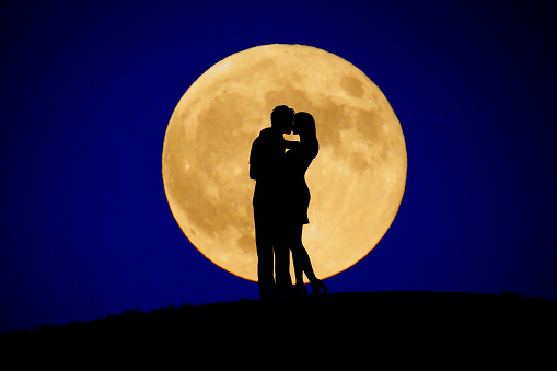 Two people to kiss the moon in back