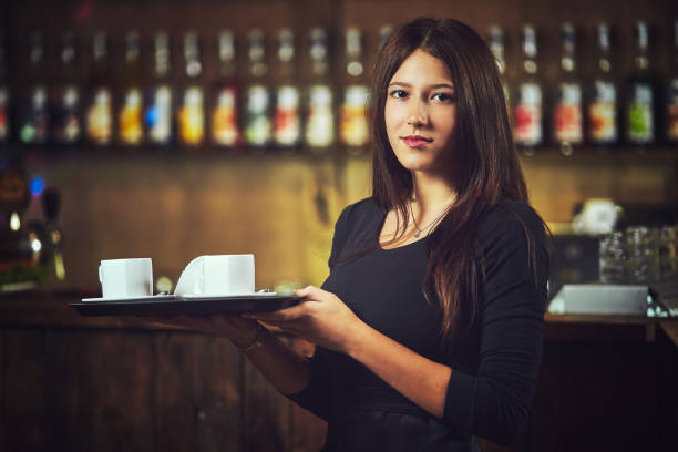 Female Waitress Carrying Glasses And Beepers