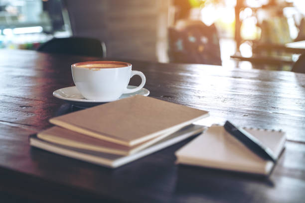istock Notebooks, pen and coffee cup on wooden table in cafe 1063317924