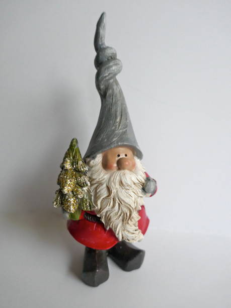 istock Christmas garden gnome with a small christmas tree in hand.Isolated on white 1063318940