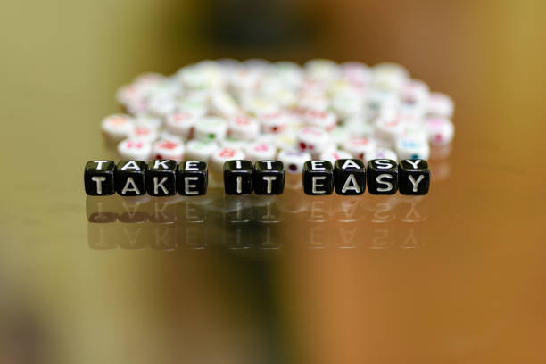 istock TAKE IT EASY written with Acrylic Black cube with white Alphabet Beads on the Glass Background 1063328770