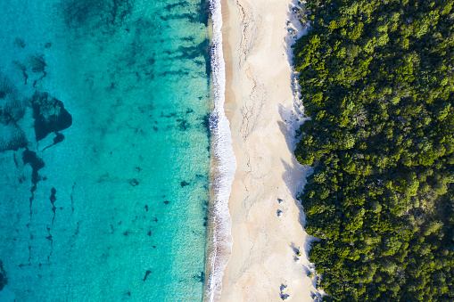 Aerial view of an amazing wild beach bathed by a transparent and turquoise sea. Sardinia, Italy.\