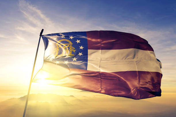 Georgia state of United States flag textile cloth fabric waving on the top sunrise mist fog Georgia state of United States flag on flagpole textile cloth fabric waving on the top sunrise mist fog georgia country photos stock pictures, royalty-free photos & images