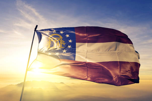 Georgia state of United States flag textile cloth fabric waving on the top sunrise mist fog Georgia state of United States flag on flagpole textile cloth fabric waving on the top sunrise mist fog georgia flag country stock pictures, royalty-free photos & images