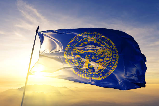 nebraska estado de los estados unidos textiles tela tela de la bandera ondeando en la niebla de la niebla de amanecer superior - bandera del estado de nebraska fotos fotografías e imágenes de stock