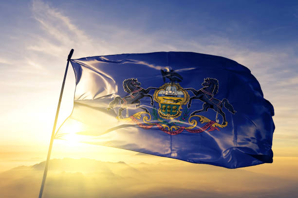 Pennsylvania state of United States flag textile cloth fabric waving on the top sunrise mist fog Pennsylvania state of United States flag on flagpole textile cloth fabric waving on the top sunrise mist fog us state flag stock pictures, royalty-free photos & images
