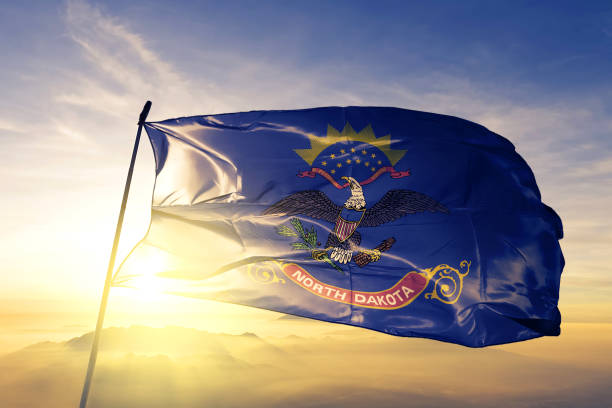 северная дакота штата соединенные штаты флаг текстильной ткани ткань размахивая на вершине туман восхода солнца - north dakota стоковые фото и изображения