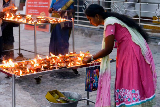 Individual puja for Lord Shani in Kapaleeshwarar Temple in Chennai, India Chennai, India - August 18, 2018: A woman light a candle in front of Lord Shani shrine in Kapaleeshwarar Temple for an individual puja. Puja is a prayer ritual performed by Hindus kapaleeswarar temple photos stock pictures, royalty-free photos & images