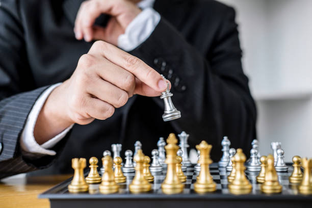 istock Hands of confident businessman playing chess game to development analysis new strategy plan, leader and teamwork concept for win and success 1063342710