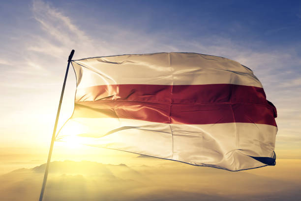 istock Belarus 1918 belarussian white-red-white flag textile cloth fabric waving on the top sunrise mist fog 1063346384