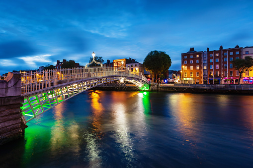 The famous illuminated Ha'penny Bridge over the River Liffey in Dublin at Twilight, Ireland.